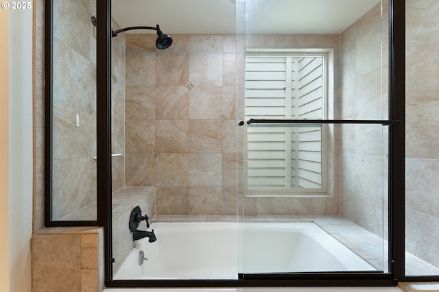 bathroom with shower / bath combination with glass door