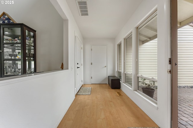 corridor with visible vents and light wood-style floors