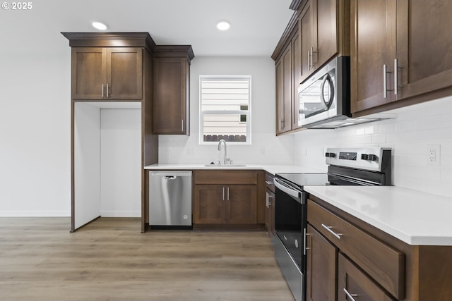 1912 NW 18th Ave, Battle Ground, WA 98604 - kitchen featuring a sink, tasteful backsplash, light wood-style flooring, and appliances with stainless steel finishes