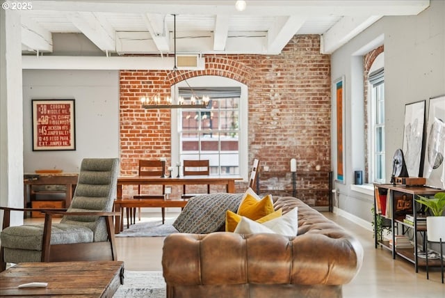 living area featuring baseboards, arched walkways, brick wall, wood finished floors, and beam ceiling