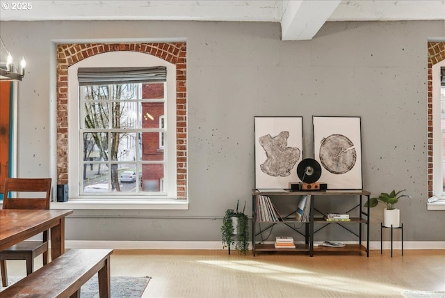 interior space with beam ceiling, baseboards, and wood finished floors