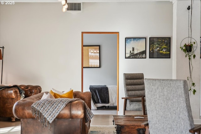 living area with visible vents and wood finished floors