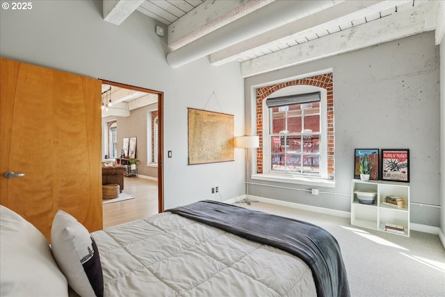 carpeted bedroom with baseboards and beamed ceiling