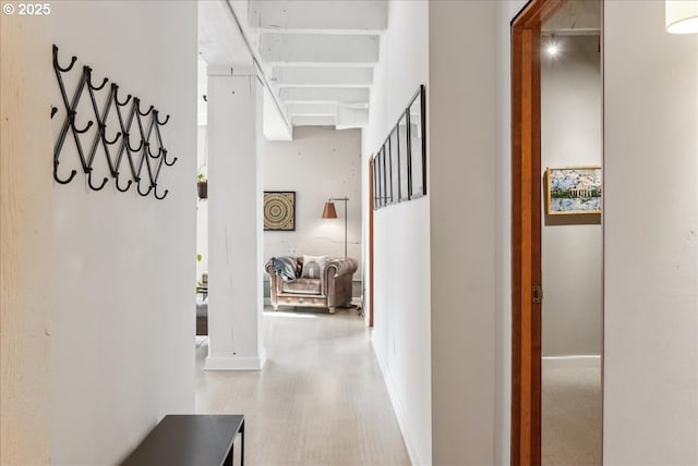 corridor featuring baseboards and wood finished floors