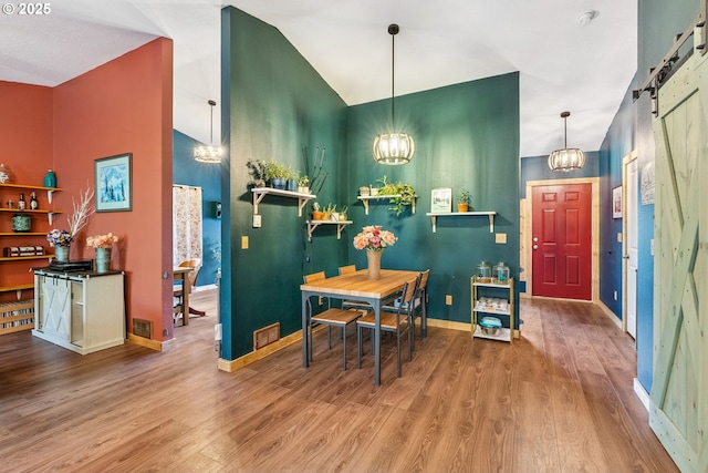 108 Watts Ave, Cascade Locks, OR 97014 - dining space with a chandelier, wood finished floors, a barn door, and high vaulted ceiling