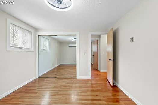 2065 Providence St, Eugene, OR 97401 - unfurnished bedroom featuring light wood finished floors, a closet, and a wall mounted AC