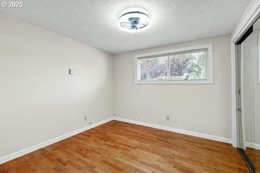 2065 Providence St, Eugene, OR 97401 - unfurnished bedroom featuring wood finished floors, a closet, and a textured ceiling