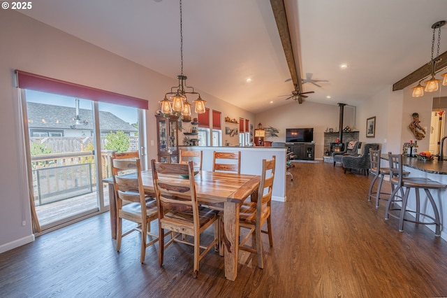 dining space featuring vaulted ceiling with beams, dark wood-style floors, and ceiling fan with notable chandelier