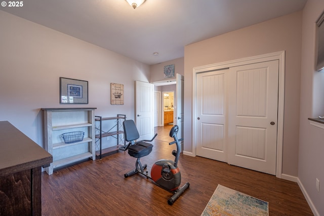 exercise area featuring baseboards and wood finished floors