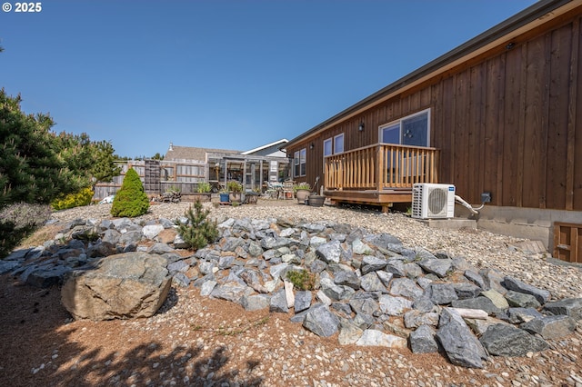view of yard with fence, a wooden deck, and ac unit