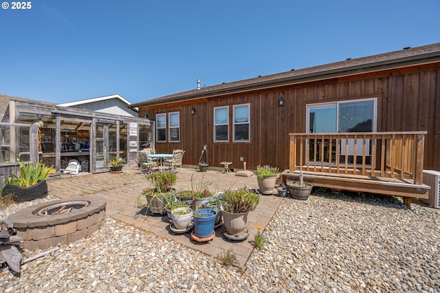 rear view of house with an outdoor fire pit, an outdoor structure, an exterior structure, and a patio area