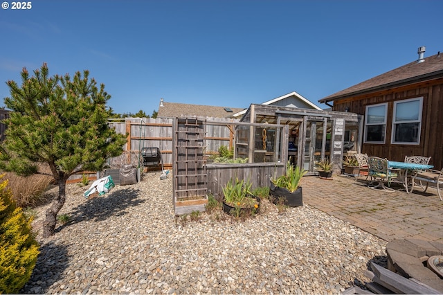 view of yard featuring fence, a patio, and a greenhouse