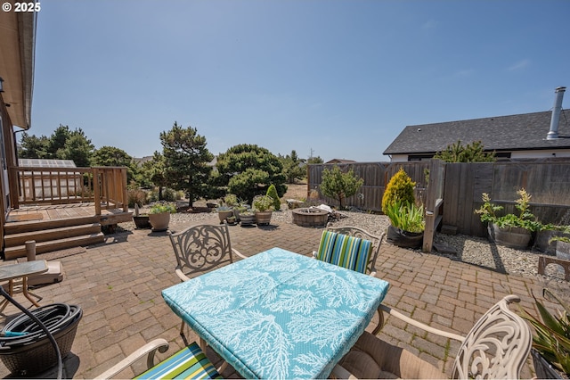 view of patio / terrace with a fire pit, a fenced backyard, and outdoor dining area