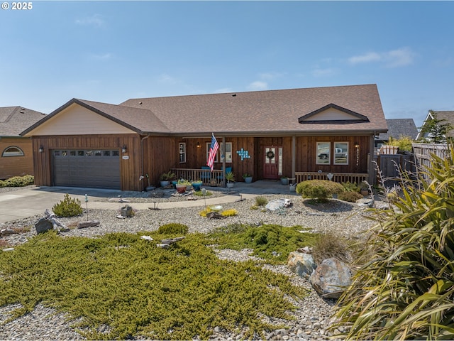 ranch-style home with driveway, an attached garage, covered porch, and fence