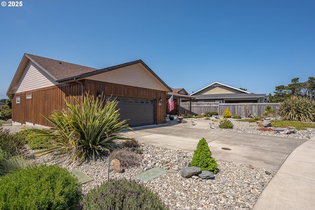 view of home's exterior featuring a garage, fence, and driveway