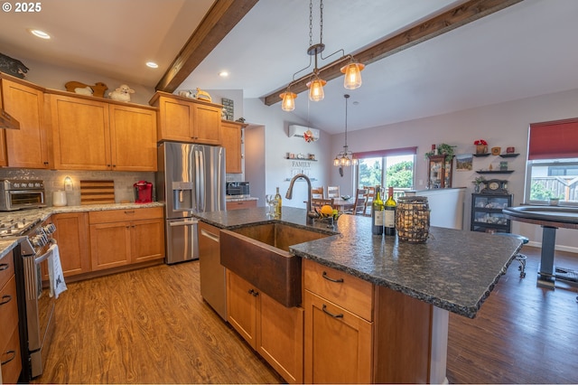 kitchen featuring lofted ceiling with beams, a sink, a wealth of natural light, and stainless steel appliances
