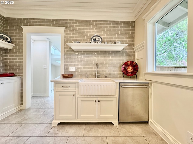 kitchen featuring open shelves, stainless steel dishwasher, crown molding, a sink, and light countertops