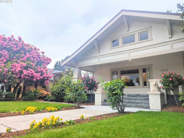 craftsman-style home with covered porch and a front lawn