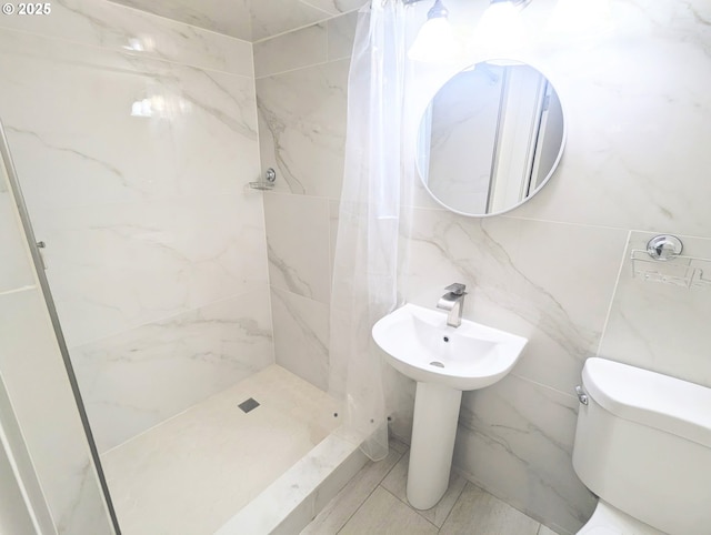 bathroom featuring a shower stall, toilet, and tile walls