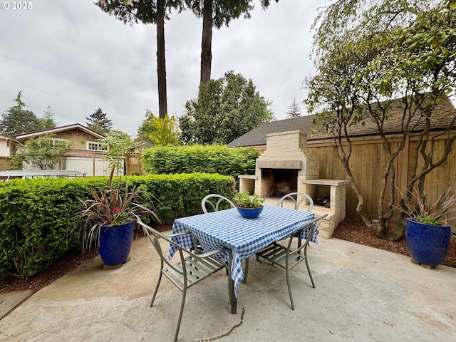 view of patio / terrace featuring an outdoor stone fireplace, outdoor dining space, and fence