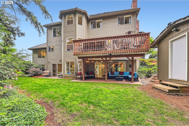 rear view of property with outdoor lounge area, a yard, a patio, a chimney, and a deck