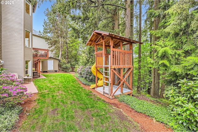view of grassy yard featuring a storage shed, an outdoor structure, and a playground