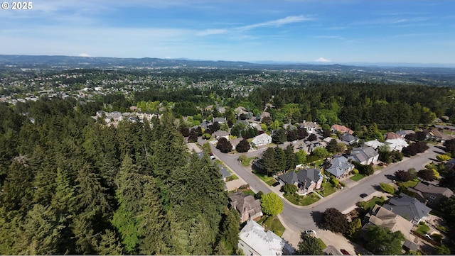 aerial view of property's location featuring a heavily wooded area and nearby suburban area