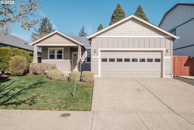 view of front of property with a garage, fence, driveway, a front lawn, and board and batten siding