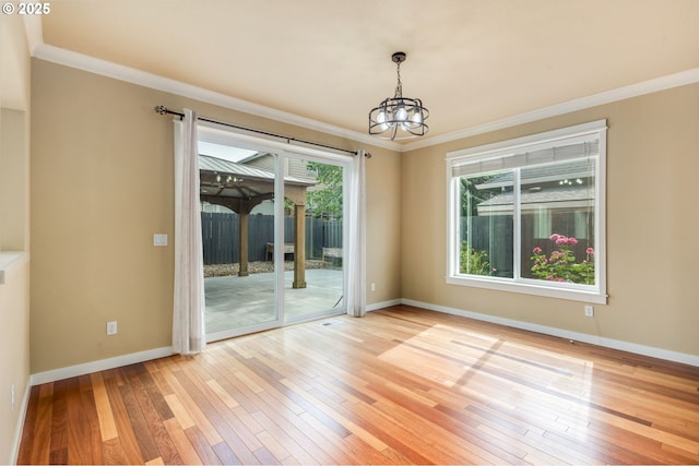 14956 SE Pebble Beach Dr, Happy Valley, OR 97086 - spare room with a chandelier, crown molding, and light wood-style flooring