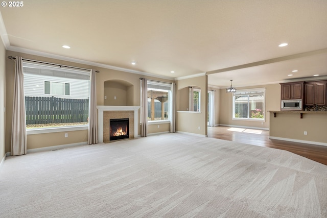 14956 SE Pebble Beach Dr, Happy Valley, OR 97086 - unfurnished living room with carpet floors, ornamental molding, a fireplace with flush hearth, a chandelier, and recessed lighting