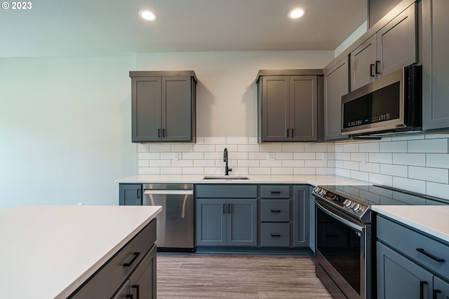 304 N Bridgeton Rd, Portland, OR 97217 - kitchen with stainless steel appliances, recessed lighting, light countertops, tasteful backsplash, and light wood-style floors