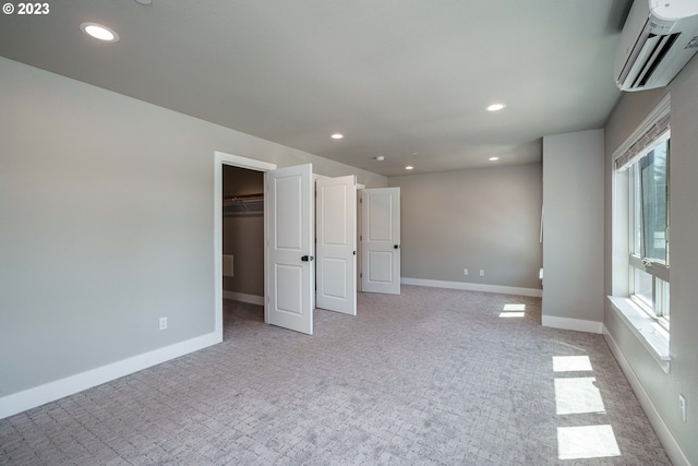 304 N Bridgeton Rd, Portland, OR 97217 - unfurnished bedroom featuring a wall unit AC, light carpet, recessed lighting, and a walk in closet