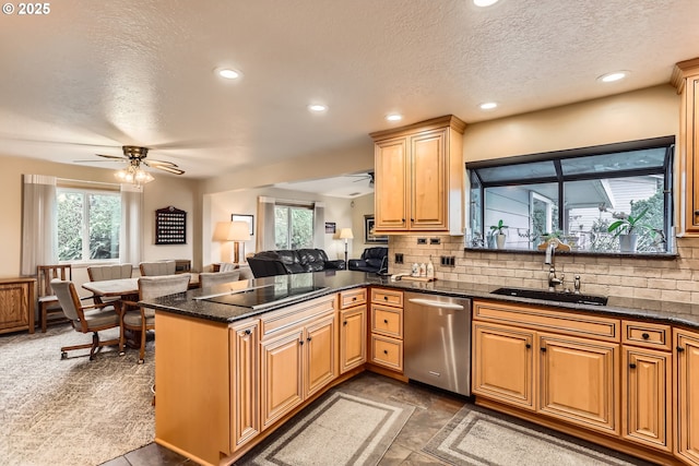kitchen with a ceiling fan, a sink, backsplash, open floor plan, and dishwasher