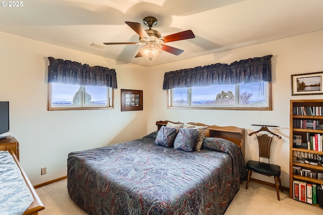 carpeted bedroom with visible vents, a ceiling fan, and baseboards