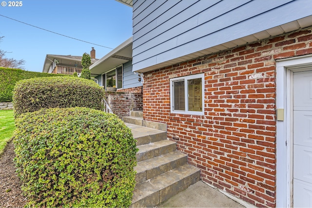 doorway to property with brick siding