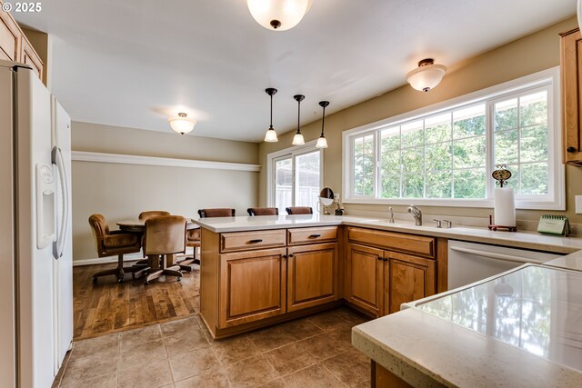 488 Pinto Way, Eugene, OR 97401 - kitchen with white appliances, a sink, brown cabinetry, light countertops, and a peninsula
