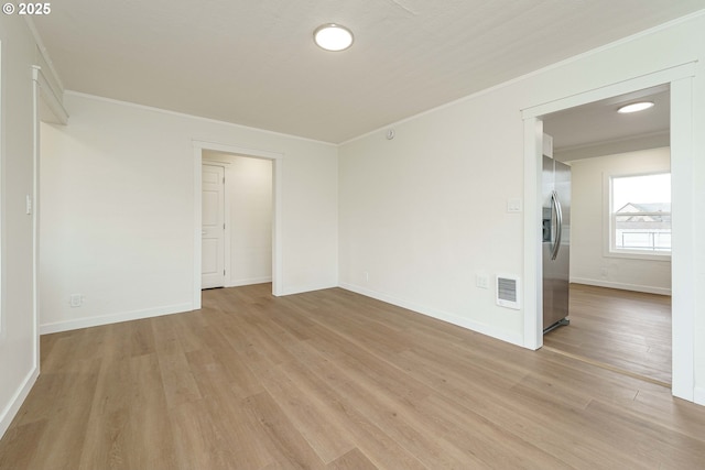 unfurnished room with crown molding and light hardwood / wood-style floors