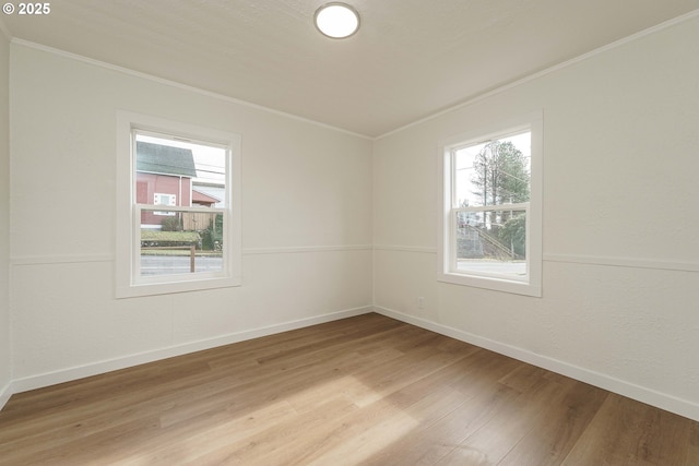 empty room featuring ornamental molding and light hardwood / wood-style flooring