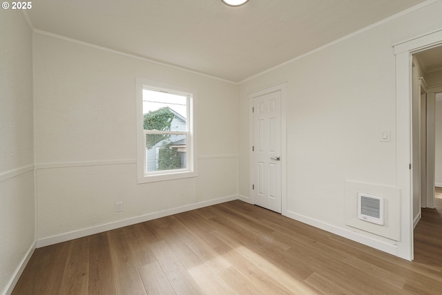 spare room featuring hardwood / wood-style flooring and ornamental molding