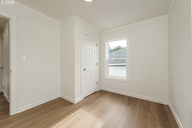 empty room featuring crown molding and light hardwood / wood-style floors