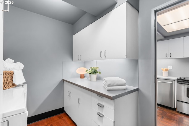 kitchen featuring stainless steel appliances, white cabinetry, and light countertops