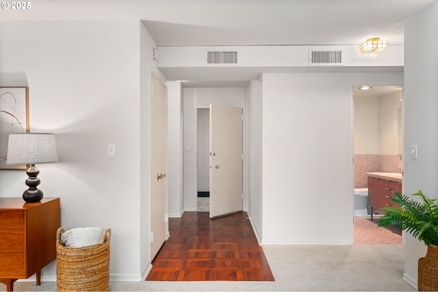 corridor featuring dark colored carpet