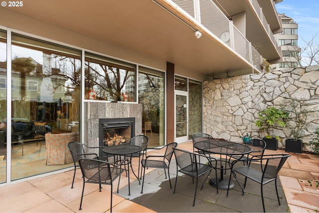view of patio with a tiled fireplace and outdoor dining space