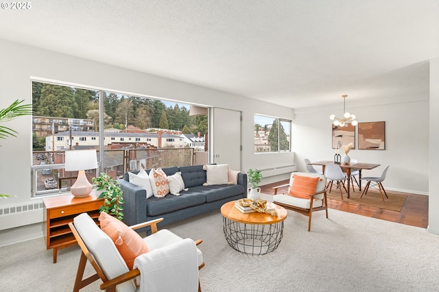 2323 SW Park Pl Unit 603, Portland, OR 97205 - living room featuring a chandelier, radiator, baseboards, and carpet
