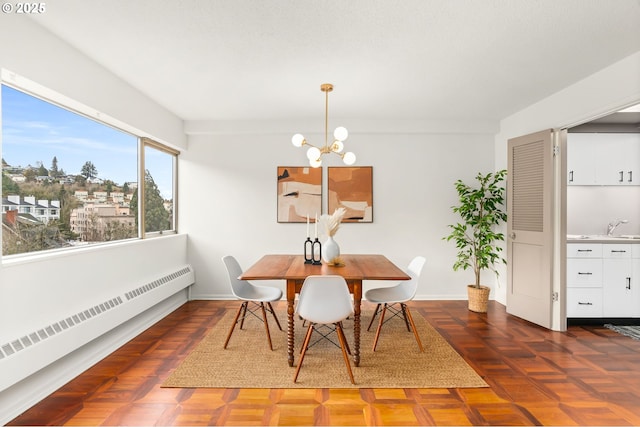 dining area with sink, a notable chandelier, dark parquet flooring, and radiator