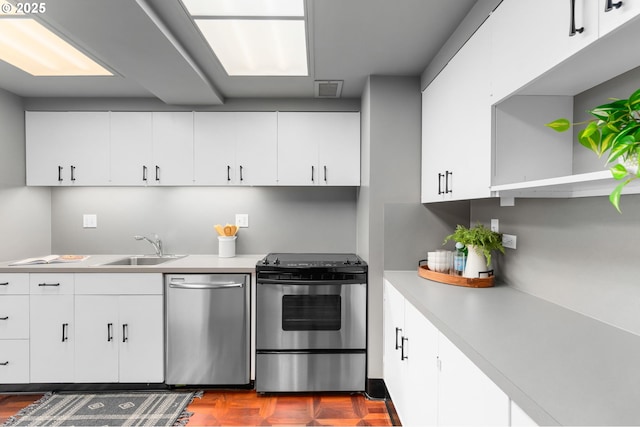 2323 SW Park Pl Unit 603, Portland, OR 97205 - kitchen featuring appliances with stainless steel finishes, a sink, light countertops, and white cabinets