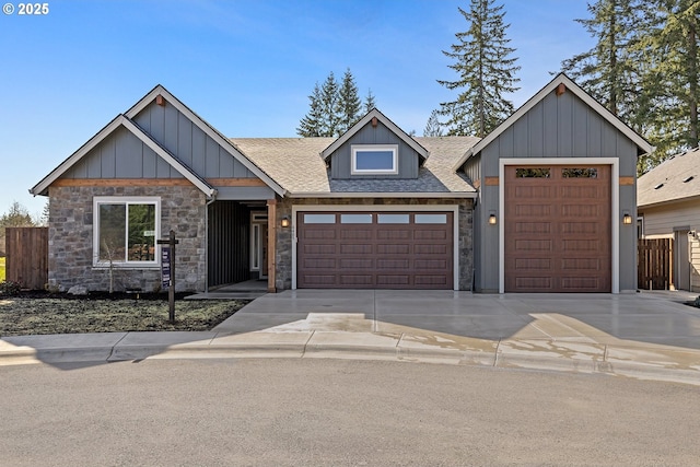 view of front of house featuring board and batten siding, fence, roof with shingles, a garage, and driveway