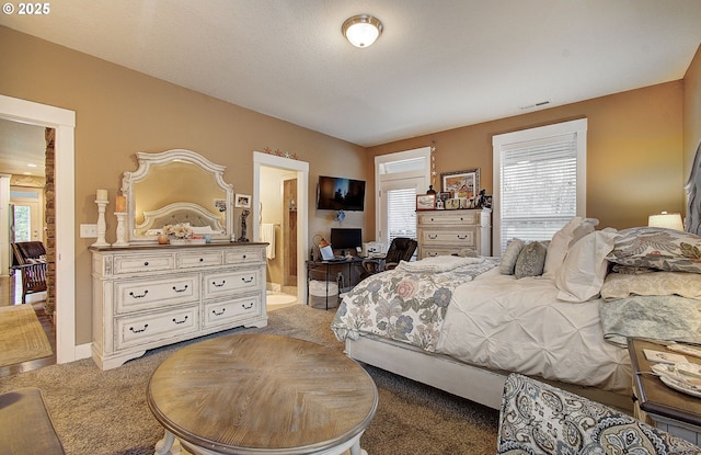 carpeted bedroom featuring ensuite bath