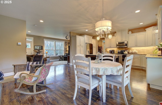 dining area featuring dark hardwood / wood-style flooring, sink, and an inviting chandelier