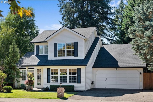 traditional-style house featuring a front yard, a garage, driveway, and roof with shingles